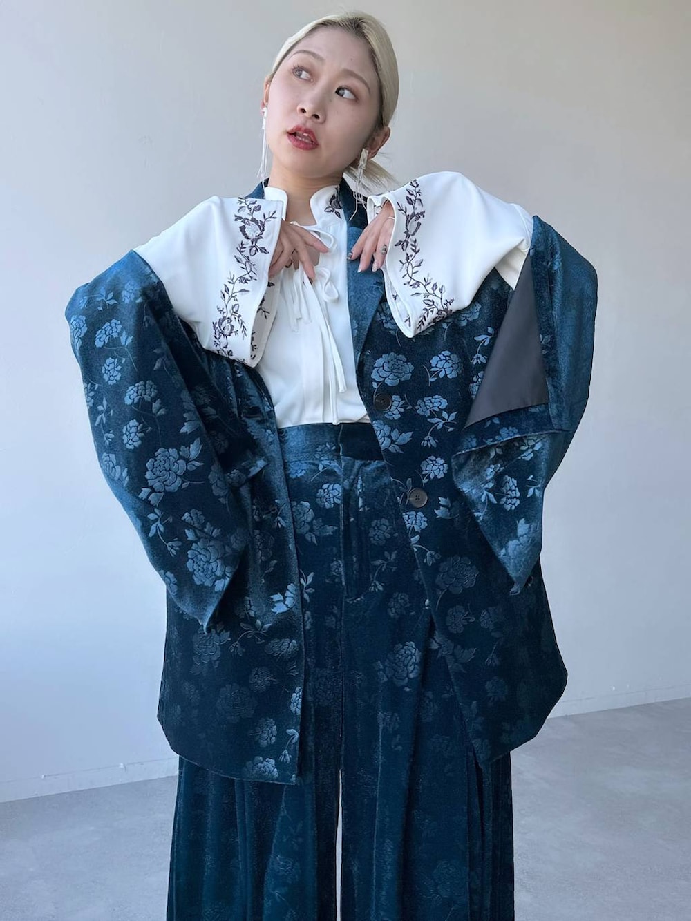 ホワイト系のシャツ/ブラウス、ブルー系のテーラードジャケット、ブラック系のブーツを着用したレディースの冬コーディネートの3枚目の写真