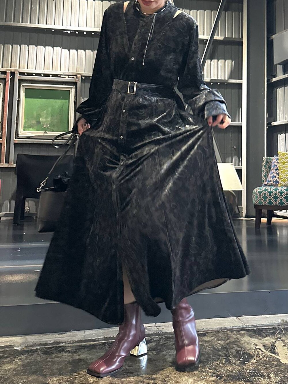 ブラック系のワンピース、レッド系のブーツ、ブラック系のショルダーバッグを着用したレディースの秋コーディネートの7枚目の写真