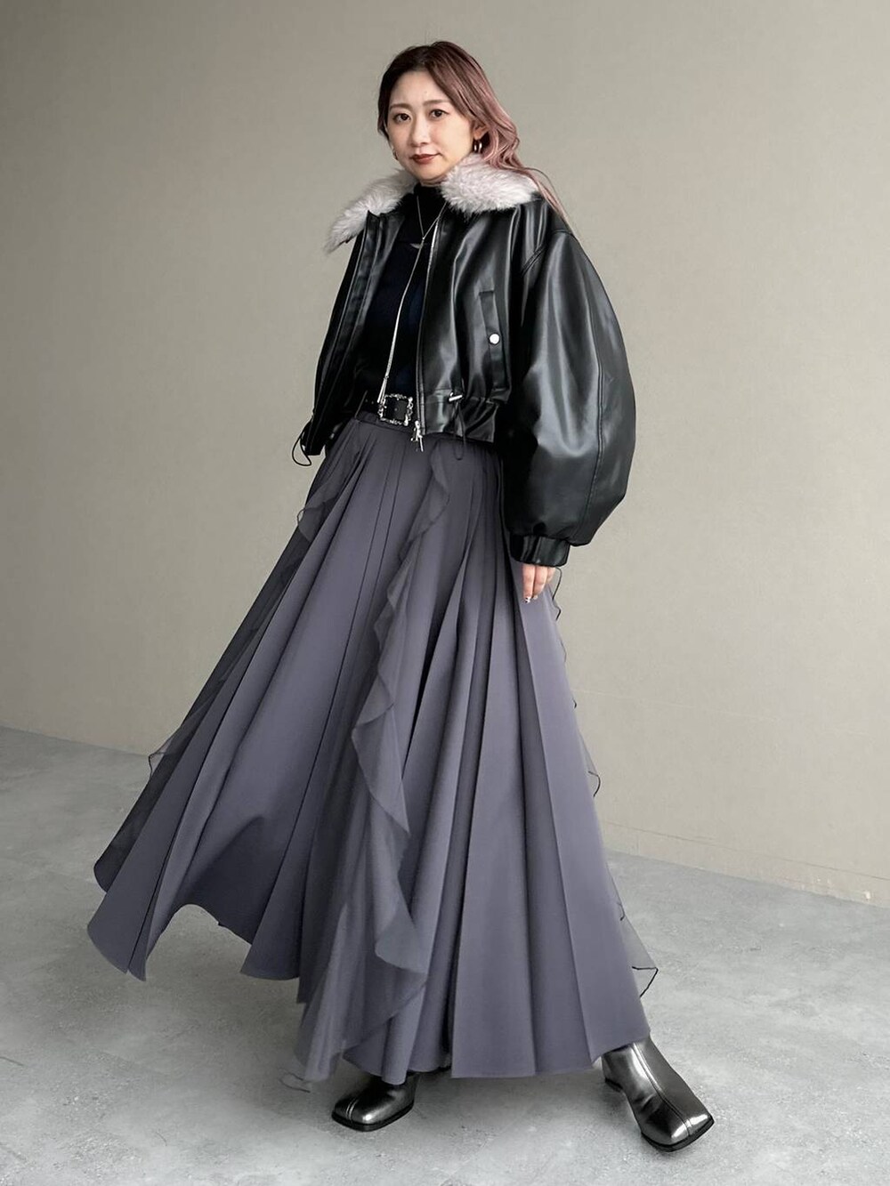 シルバー系のブーツ、ブラック系のニット/セーター、ブラック系のベルトを着用したレディースの秋コーディネートの7枚目の写真