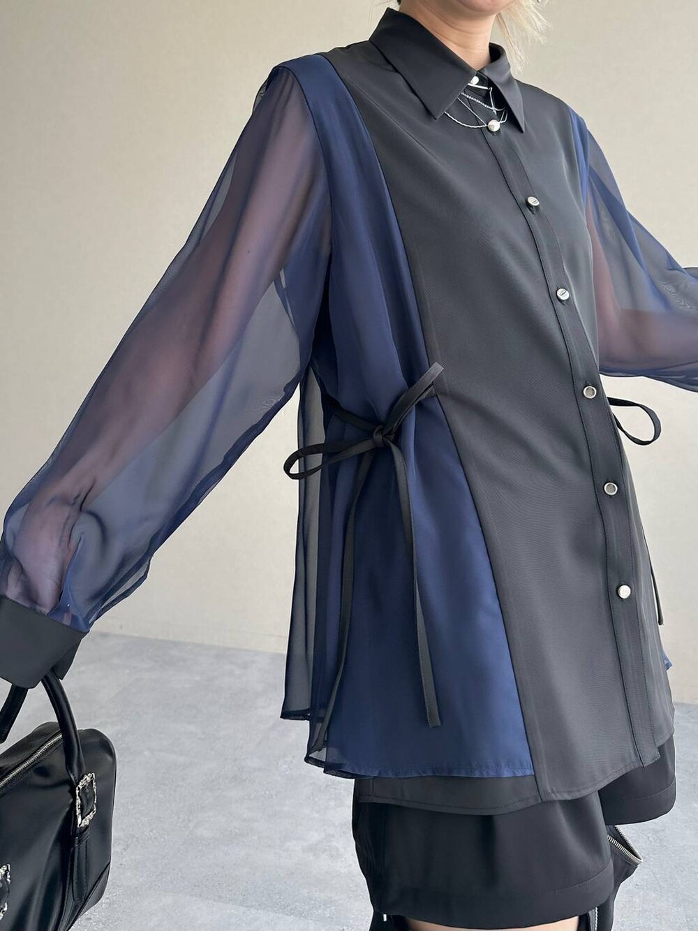 ブラック系のカーゴパンツ、ブラック系のボストンバッグ、シルバー系のブーツを着用したレディースの夏コーディネートの5枚目の写真