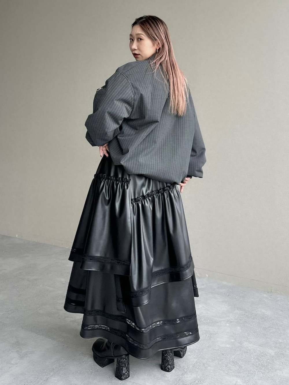 グレー系のブーツ、ブラック系のスカート、グリーン系のシャツ/ブラウスを着用したレディースの秋コーディネートの2枚目の写真