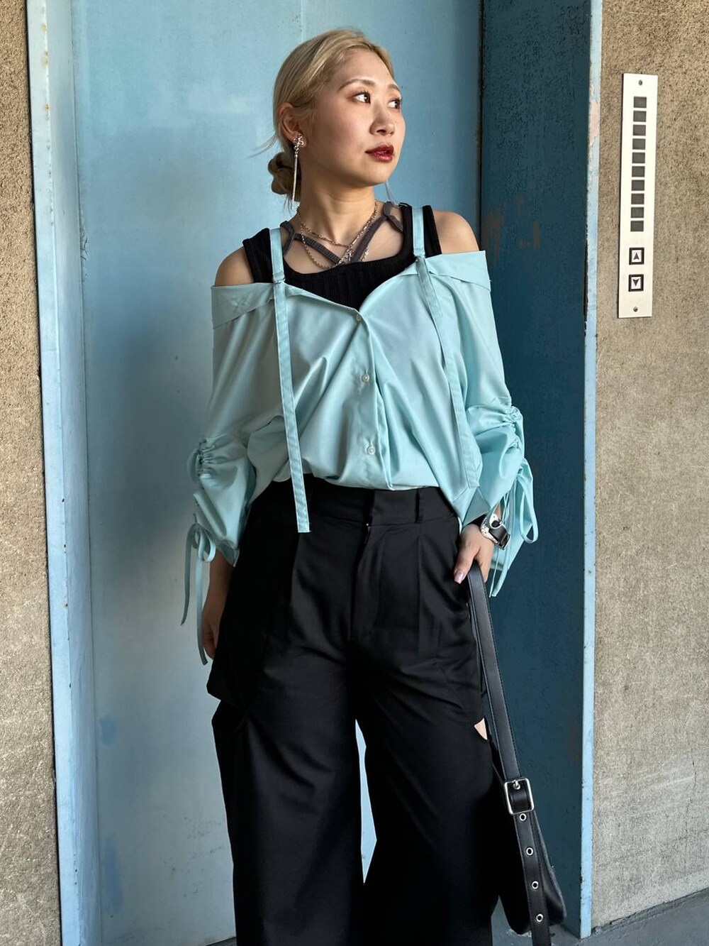 ブラック系のサンダル、ブルー系のシャツ/ブラウス、ブラック系のブレスレットを着用したレディースの春コーディネートの3枚目の写真