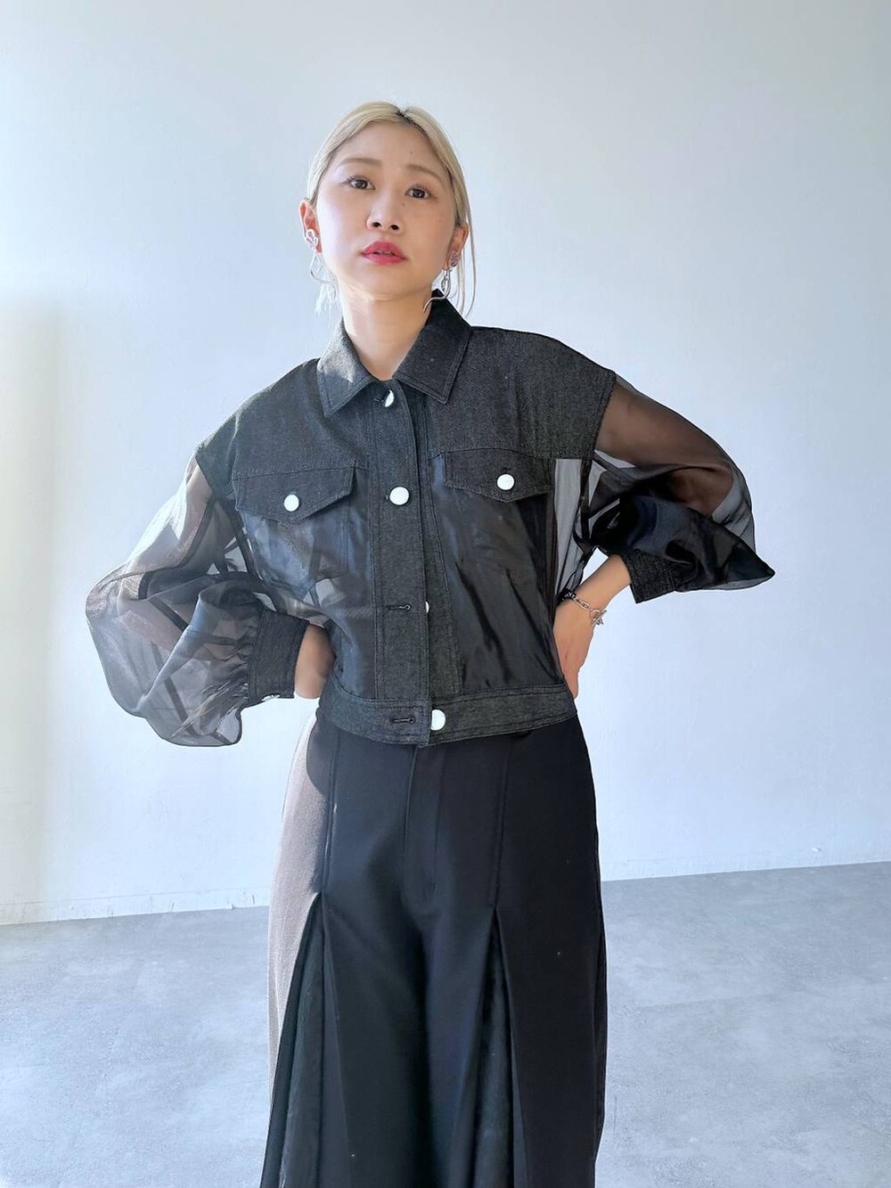 ブラック系のスラックス、ブラック系のパンプス、ブラック系のブルゾンを着用したレディースの夏コーディネートの4枚目の写真