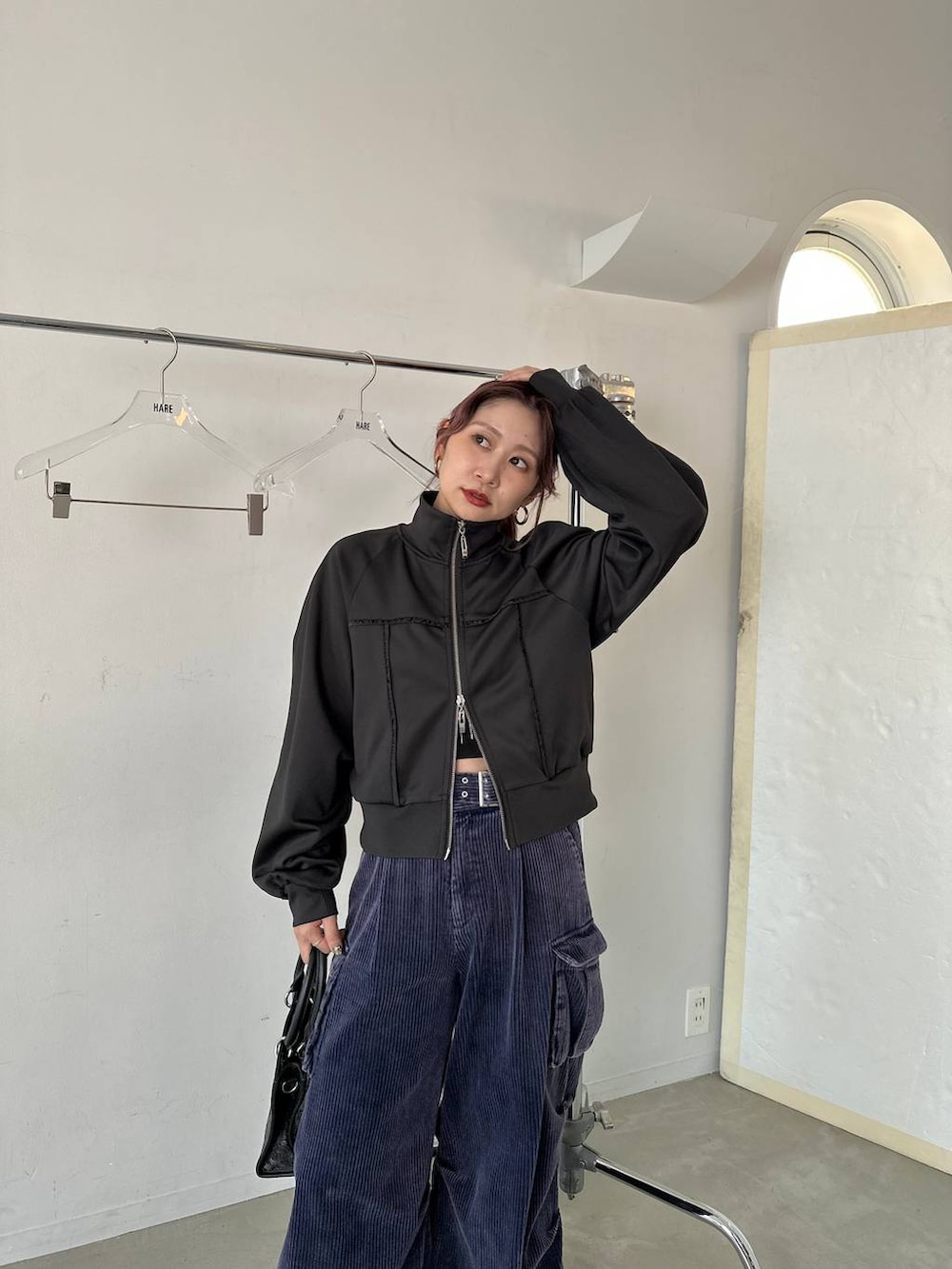 ブラック系のショルダーバッグ、ブルー系のパーカー、ブルー系のカーゴパンツを着用したレディースの秋コーディネートの4枚目の写真