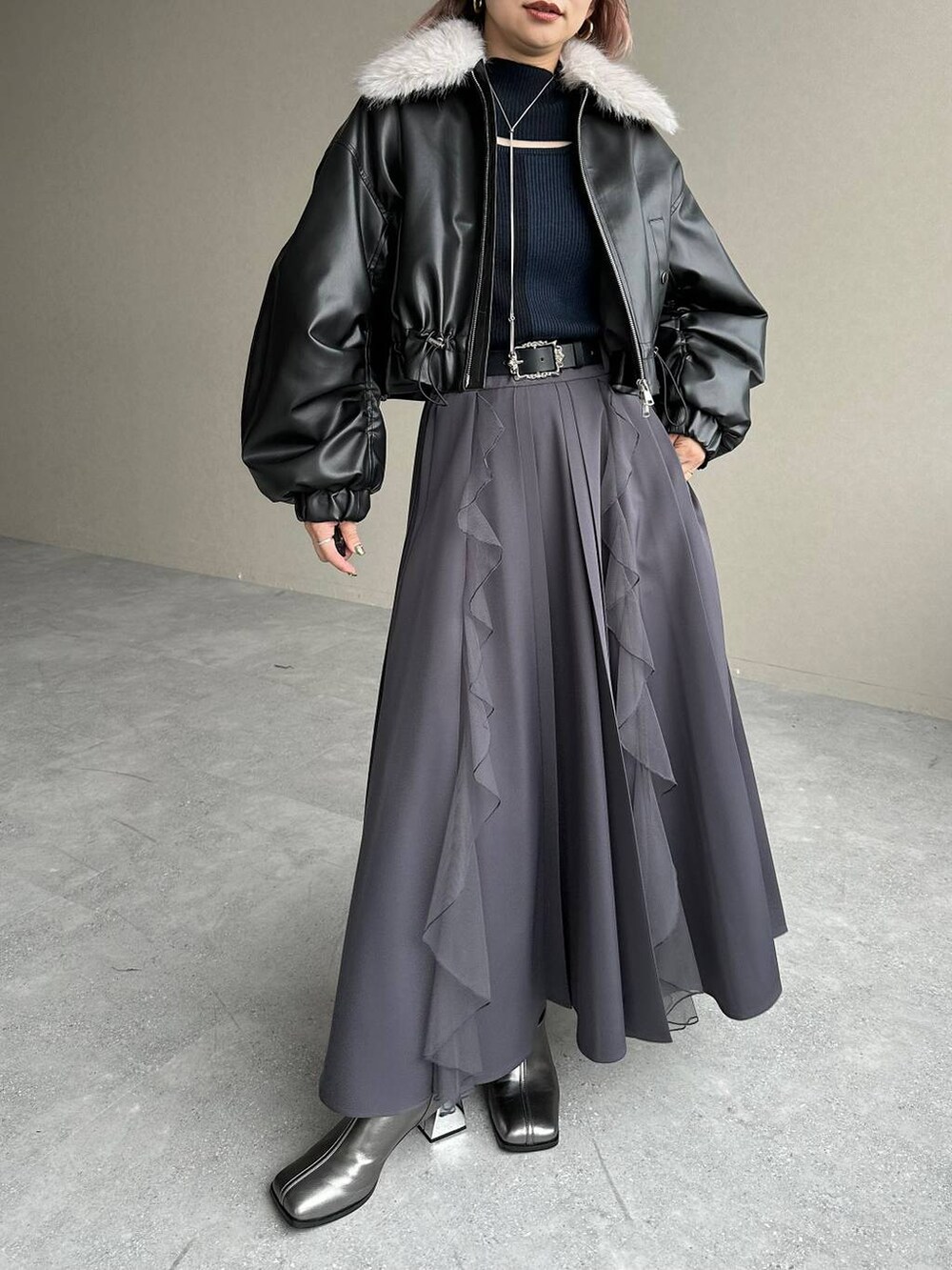 シルバー系のブーツ、ブラック系のニット/セーター、ブラック系のベルトを着用したレディースの秋コーディネートの6枚目の写真