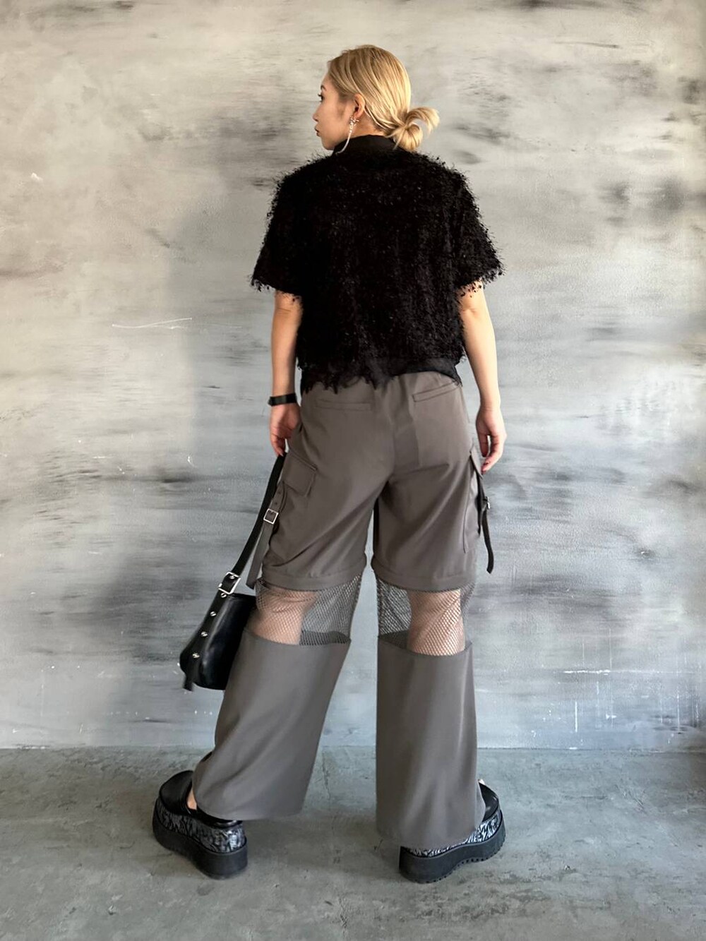 ブラック系のTシャツ/カットソー、グレー系のカーゴパンツ、ブラック系のブレスレットを着用したレディースの春コーディネートの2枚目の写真