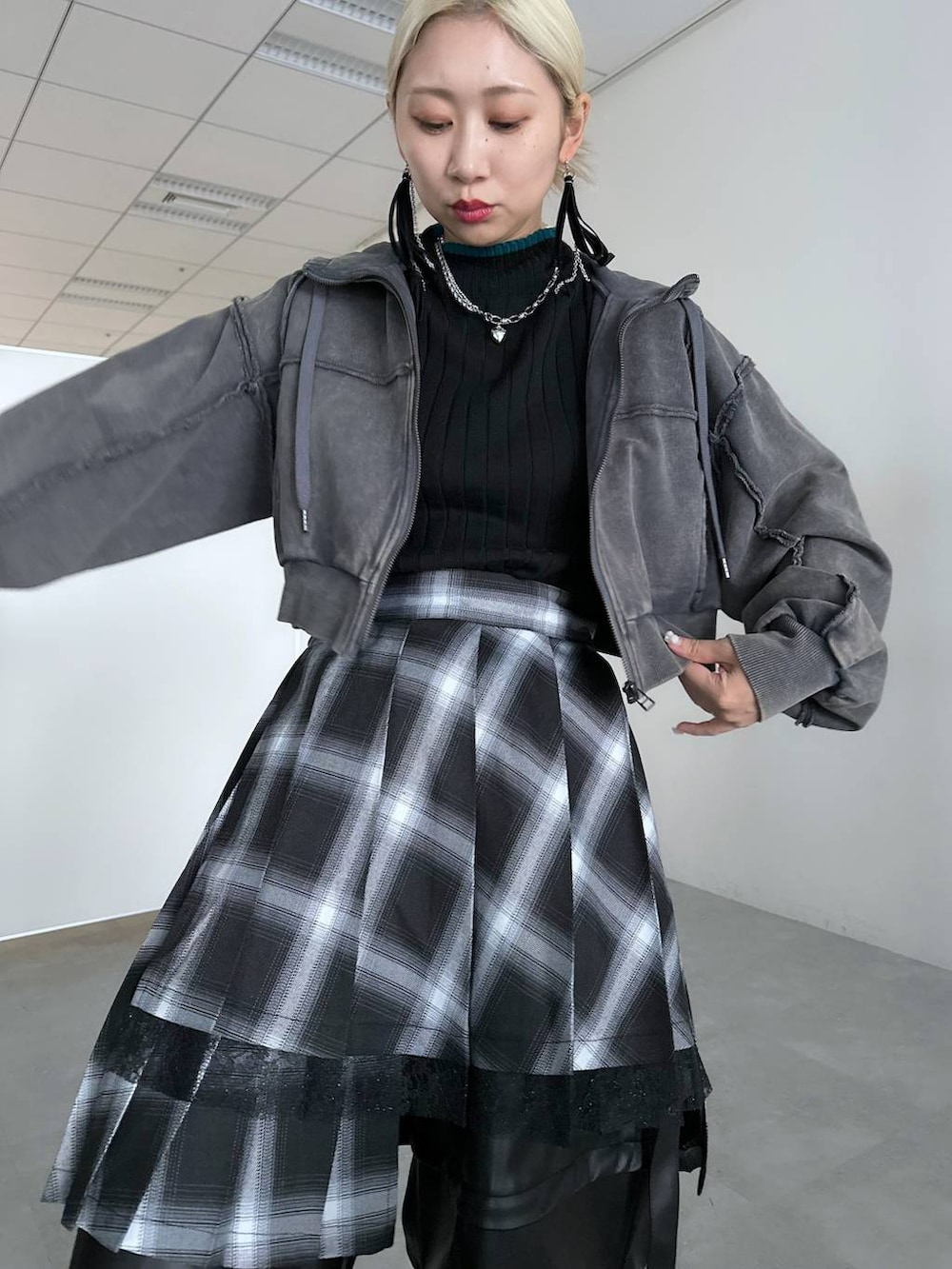 ブラック系のカーゴパンツ、ブラック系のニット/セーター、グレー系のパーカーを着用したレディースの冬コーディネートの3枚目の写真