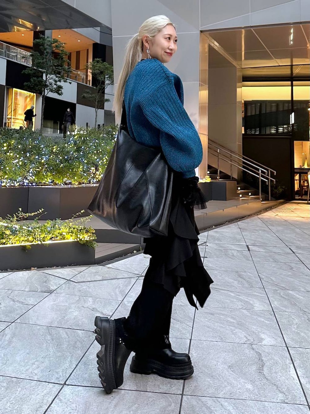 ブラック系のTシャツ/カットソー、ブラック系のブーツ、ブラック系のショルダーバッグを着用したレディースの冬コーディネートの2枚目の写真