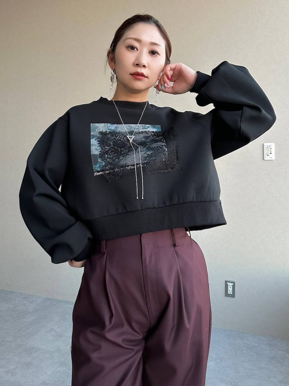 ブラック系のスニーカー、ブラック系のスウェット、レッド系のその他パンツを着用したレディースの冬コーディネートの3枚目の写真