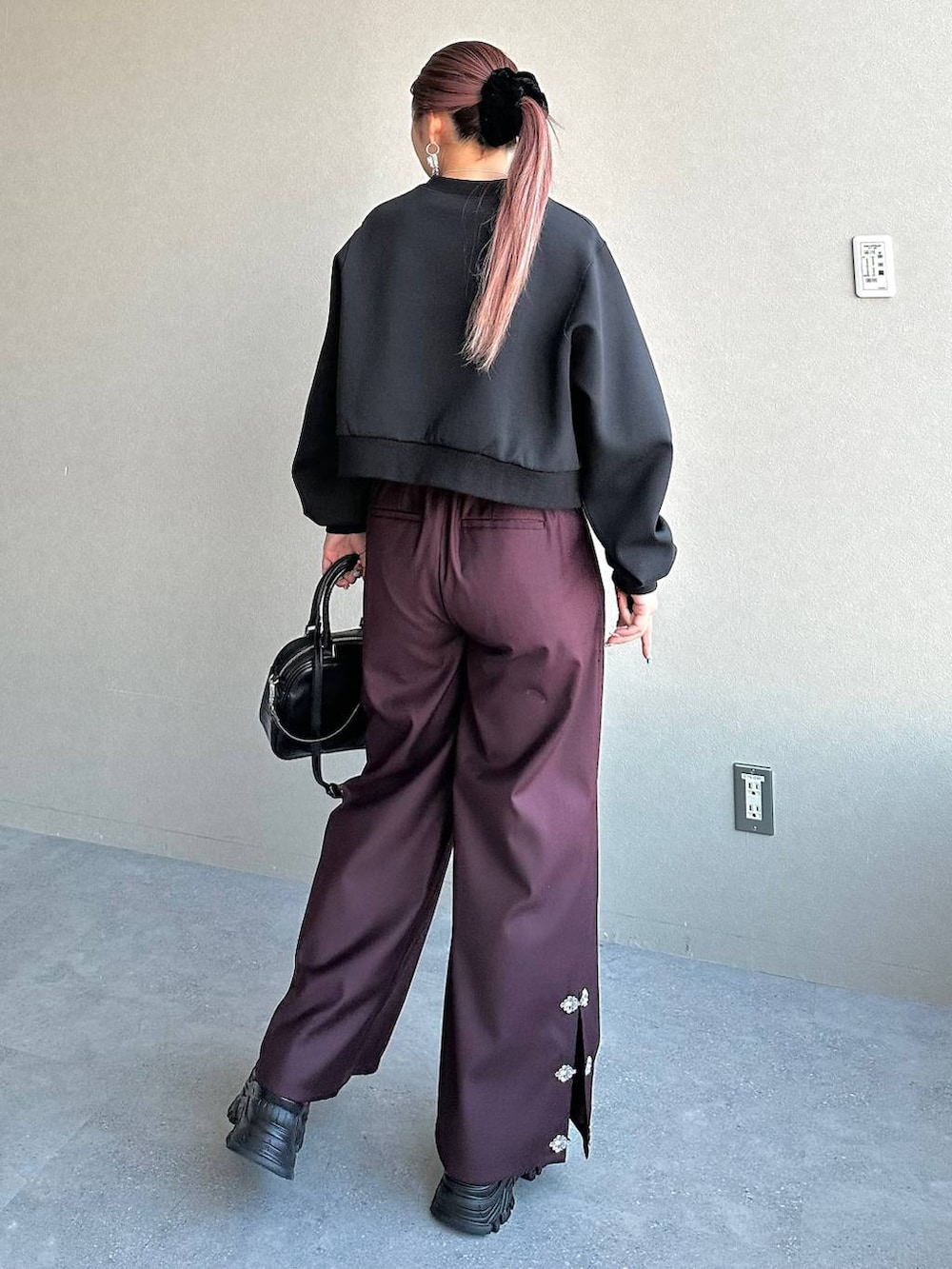 ブラック系のスニーカー、ブラック系のスウェット、レッド系のその他パンツを着用したレディースの冬コーディネートの2枚目の写真