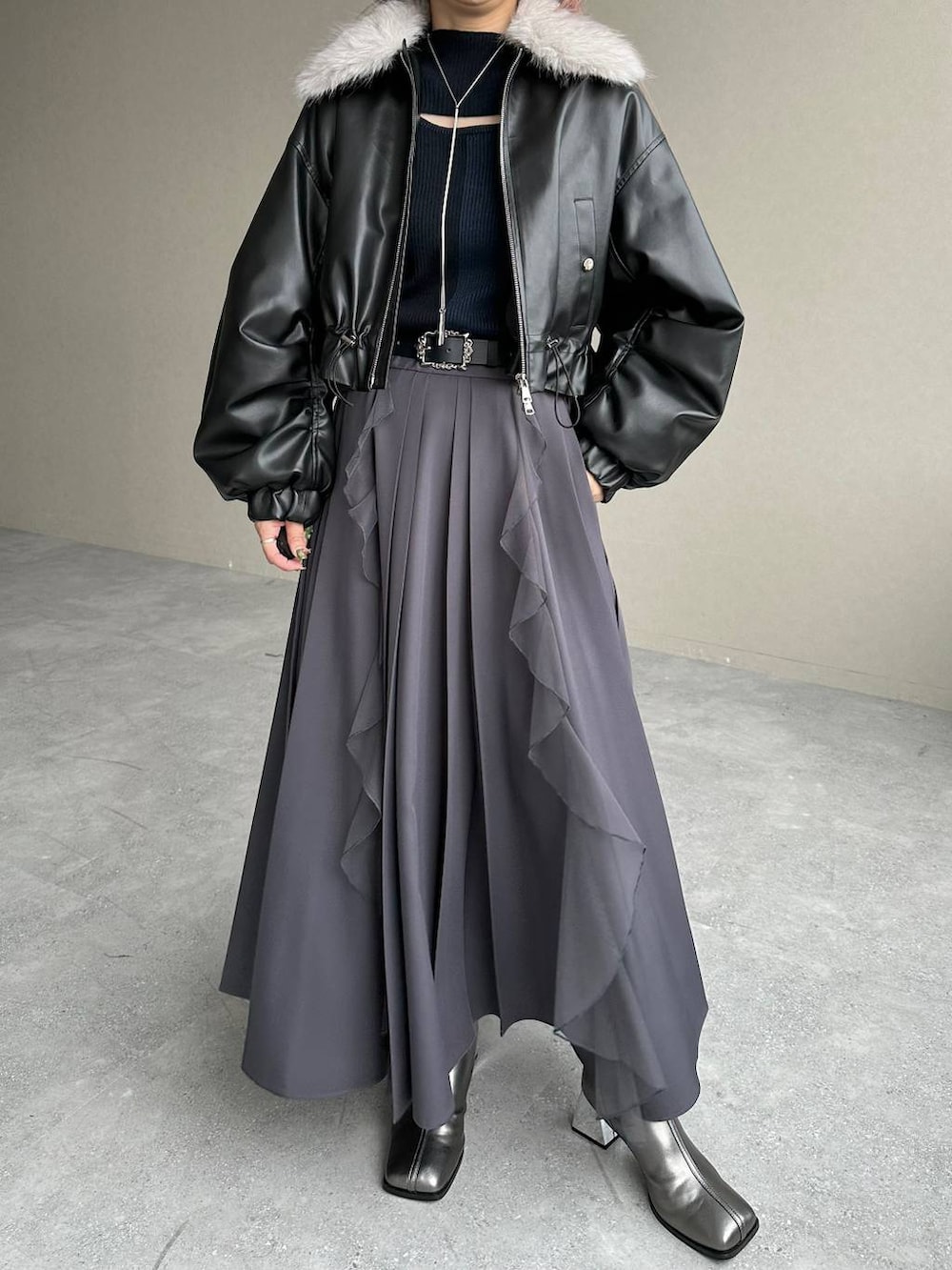 シルバー系のブーツ、ブラック系のニット/セーター、ブラック系のベルトを着用したレディースの秋コーディネートの5枚目の写真