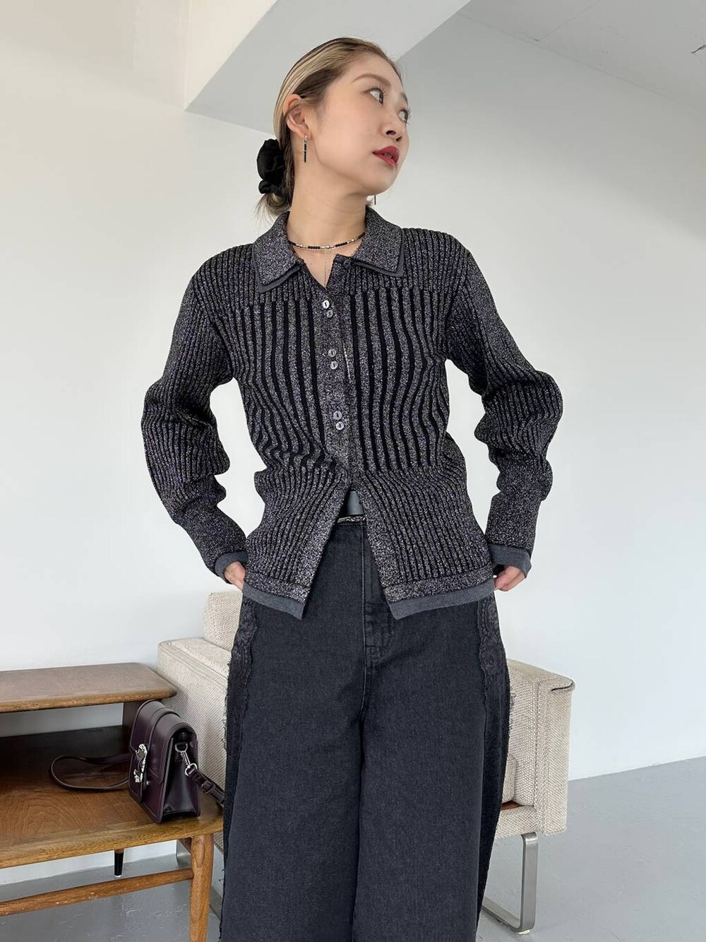 ブラック系のショルダーバッグ、ブラック系のデニムパンツ、ブラック系のブーツを着用したレディースの秋コーディネートの3枚目の写真