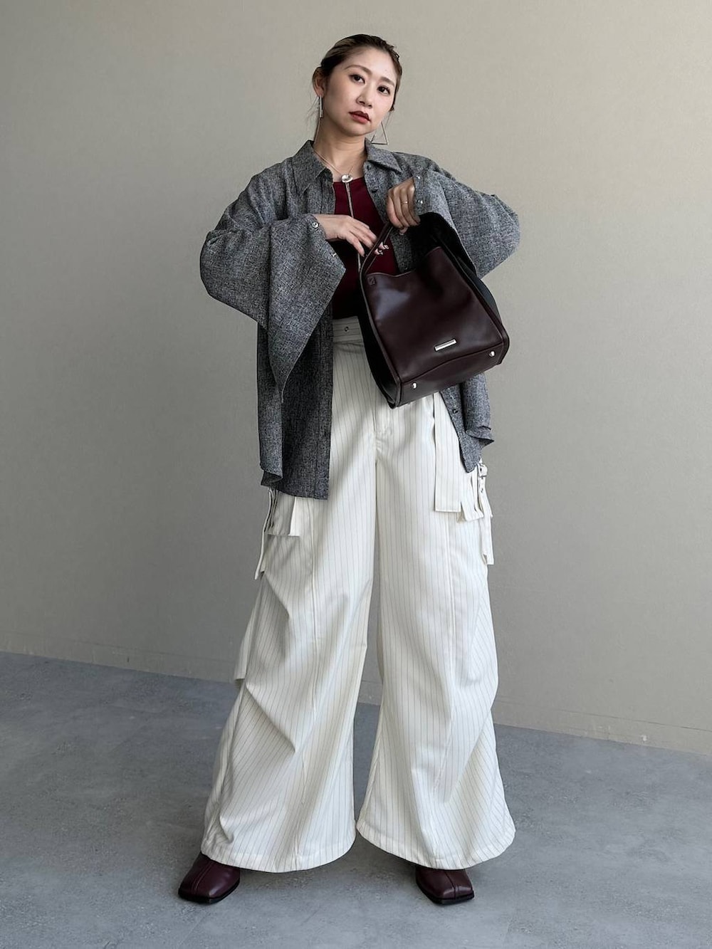 レッド系のTシャツ/カットソー、グレー系のシャツ/ブラウス、その他のカーゴパンツを着用したレディースの秋コーディネートの6枚目の写真