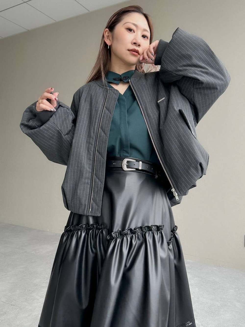 グレー系のブーツ、ブラック系のスカート、グリーン系のシャツ/ブラウスを着用したレディースの秋コーディネートの3枚目の写真