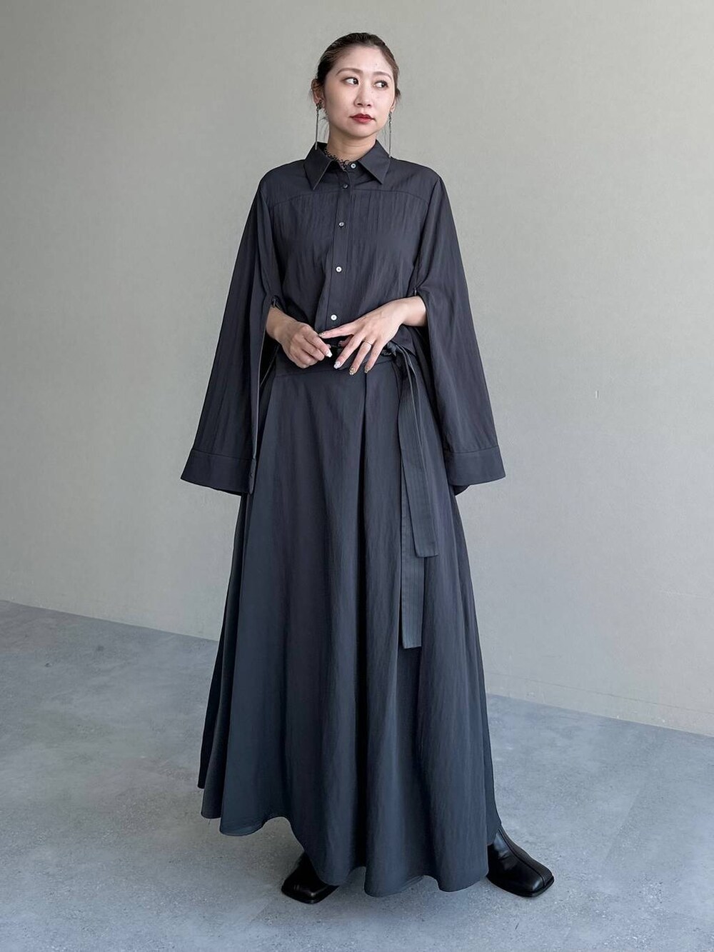 ブラック系のブーツ、グレー系のスカート、グレー系のシャツ/ブラウスを着用したレディースの秋コーディネートの8枚目の写真