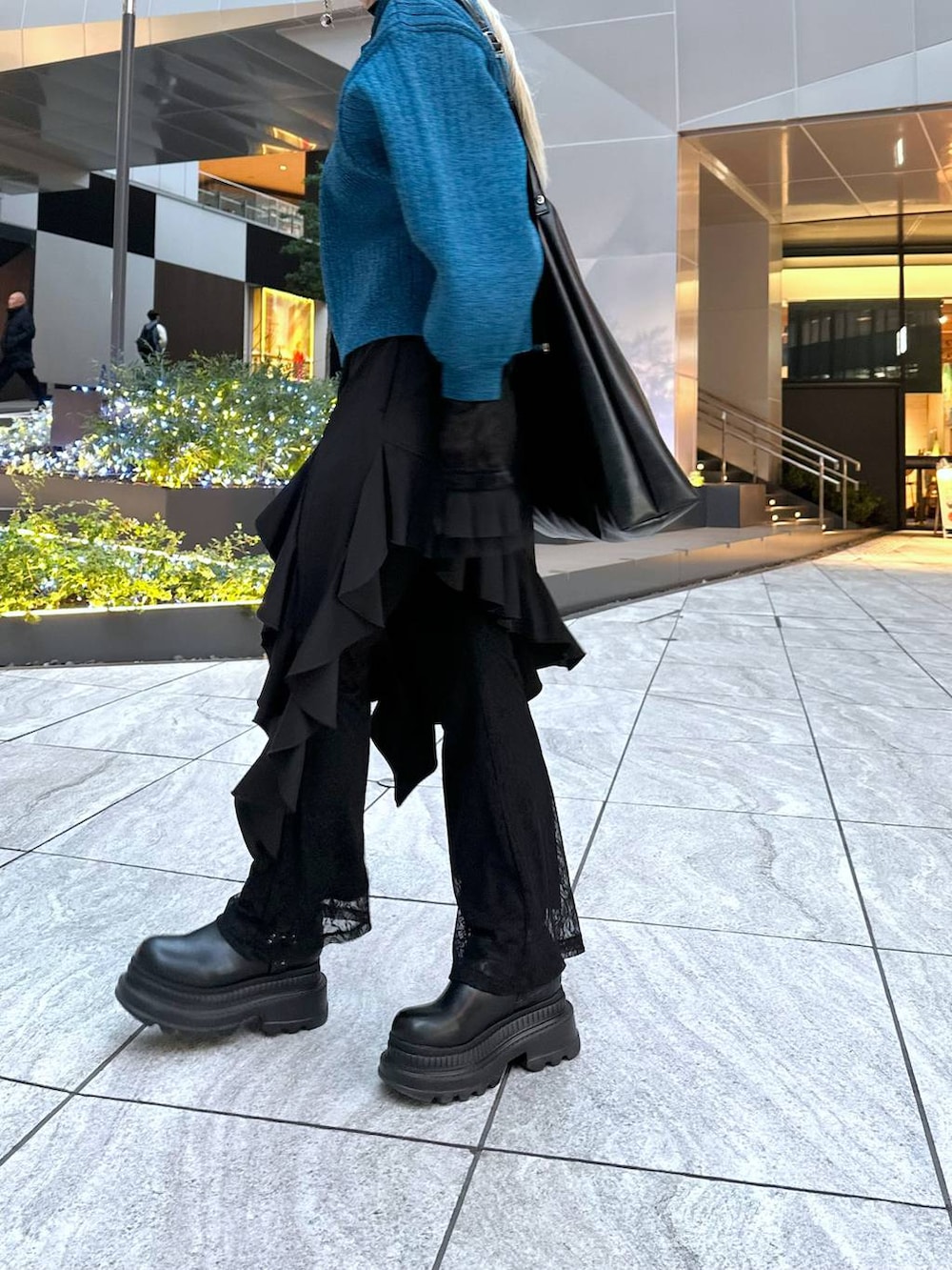 ブラック系のTシャツ/カットソー、ブラック系のブーツ、ブラック系のショルダーバッグを着用したレディースの冬コーディネートの8枚目の写真