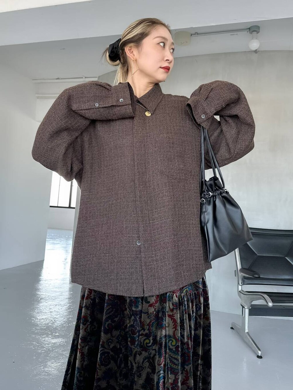 ブラック系のスカート、ブラック系のブーツ、ブラウン系のシャツ/ブラウスを着用したレディースの秋コーディネートの4枚目の写真