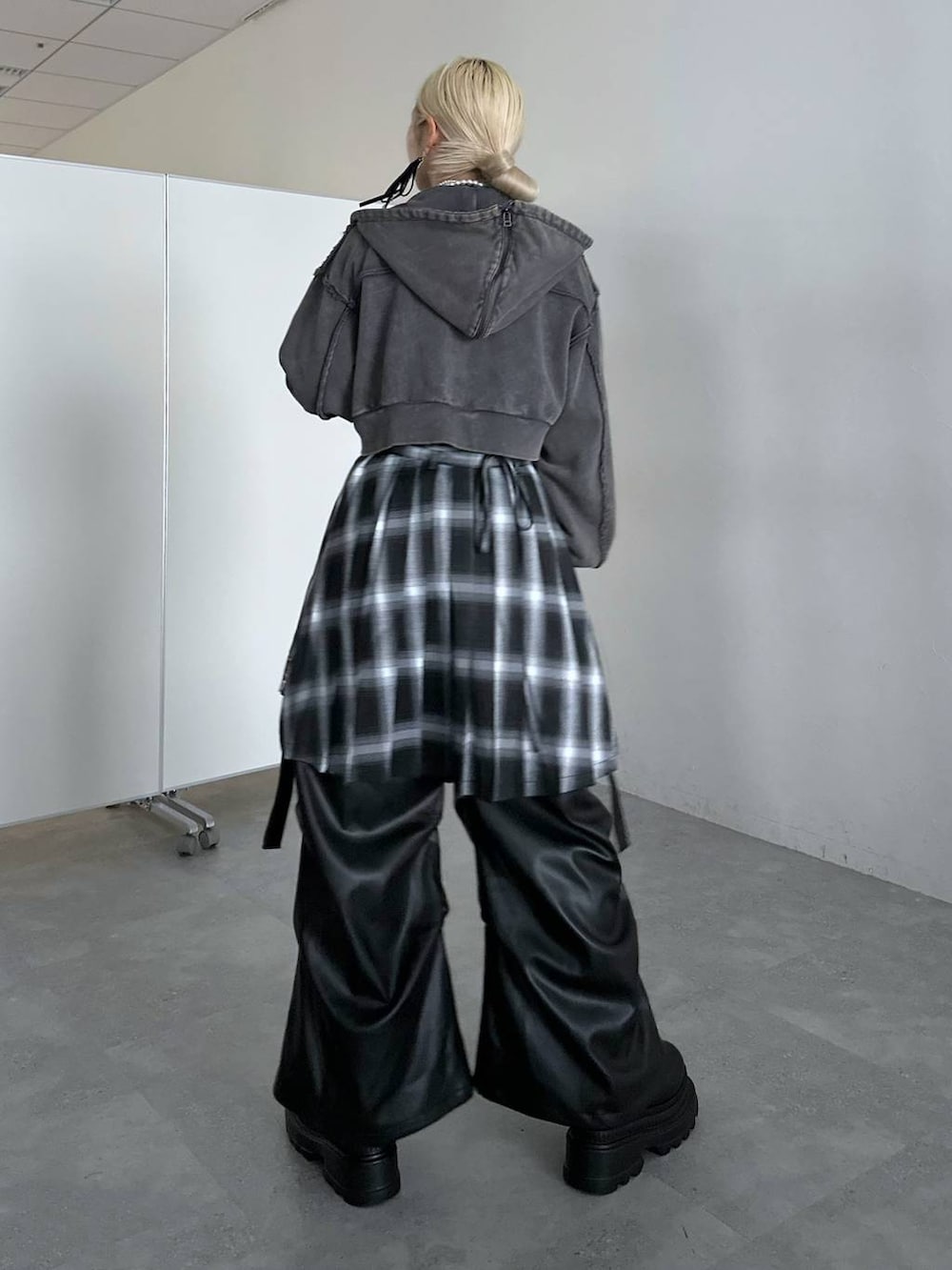 ブラック系のカーゴパンツ、ブラック系のニット/セーター、グレー系のパーカーを着用したレディースの冬コーディネートの2枚目の写真