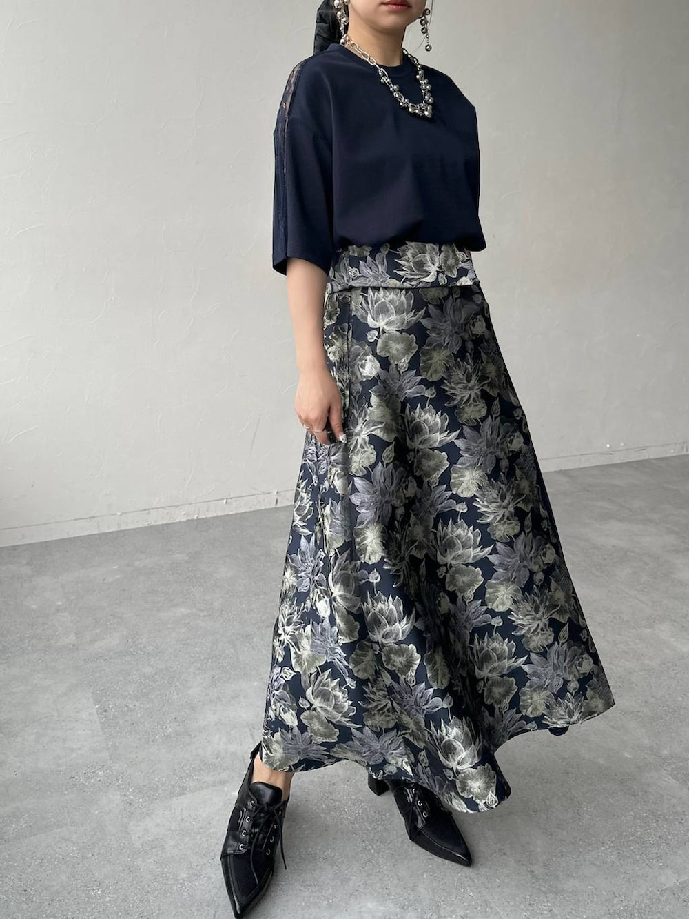 ブラック系のサンダル、ブラック系のハンドバッグ、ブルー系のスカートを着用したレディースの春コーディネートの8枚目の写真