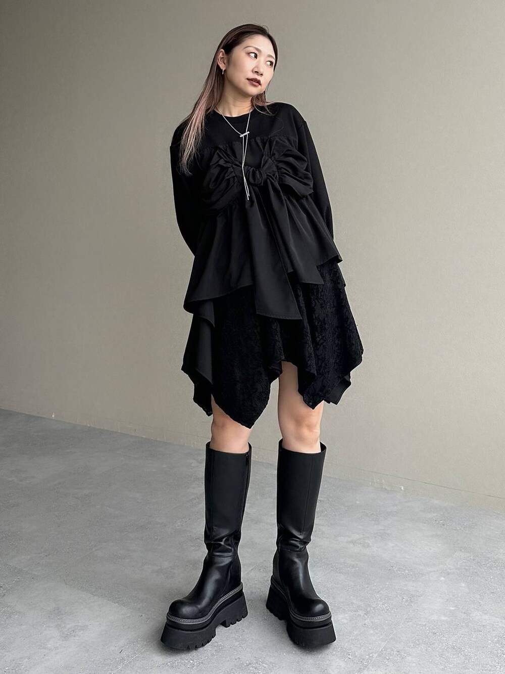 ブラック系のブーツ、ブラック系のスウェット、ブラック系のその他パンツを着用したレディースの冬コーディネートの3枚目の写真