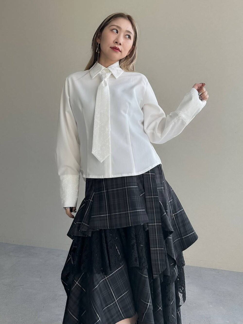 ブラック系のショルダーバッグ、ブラック系のスカート、ホワイト系のシャツ/ブラウスを着用したレディースの夏コーディネートの4枚目の写真