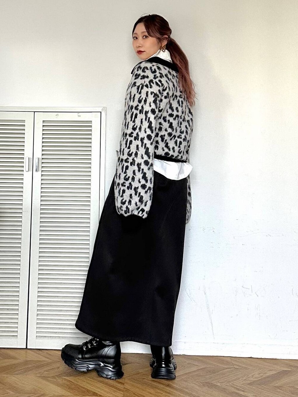 ブラック系のブーツ、ホワイト系のシャツ/ブラウス、ブラック系のスカートを着用したレディースの秋コーディネートの2枚目の写真