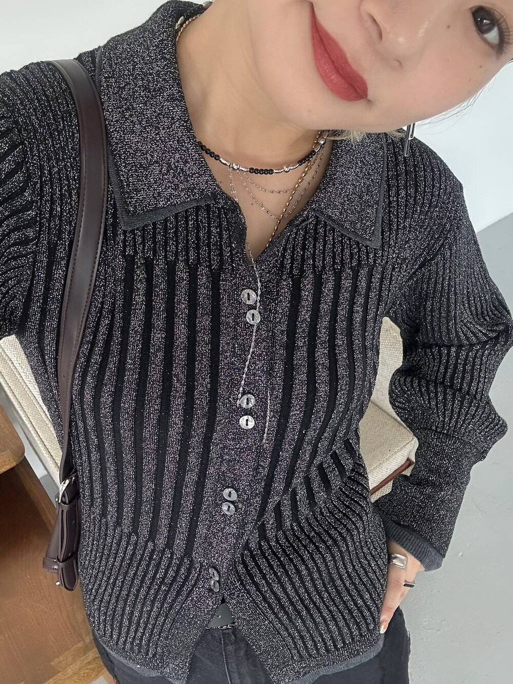 ブラック系のショルダーバッグ、ブラック系のデニムパンツ、ブラック系のブーツを着用したレディースの秋コーディネートの8枚目の写真