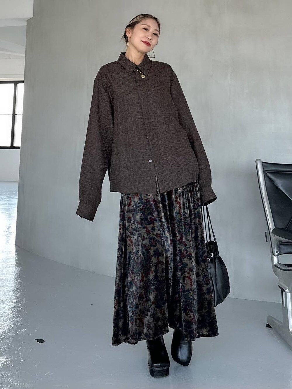 ブラック系のスカート、ブラック系のブーツ、ブラウン系のシャツ/ブラウスを着用したレディースの秋コーディネートの7枚目の写真