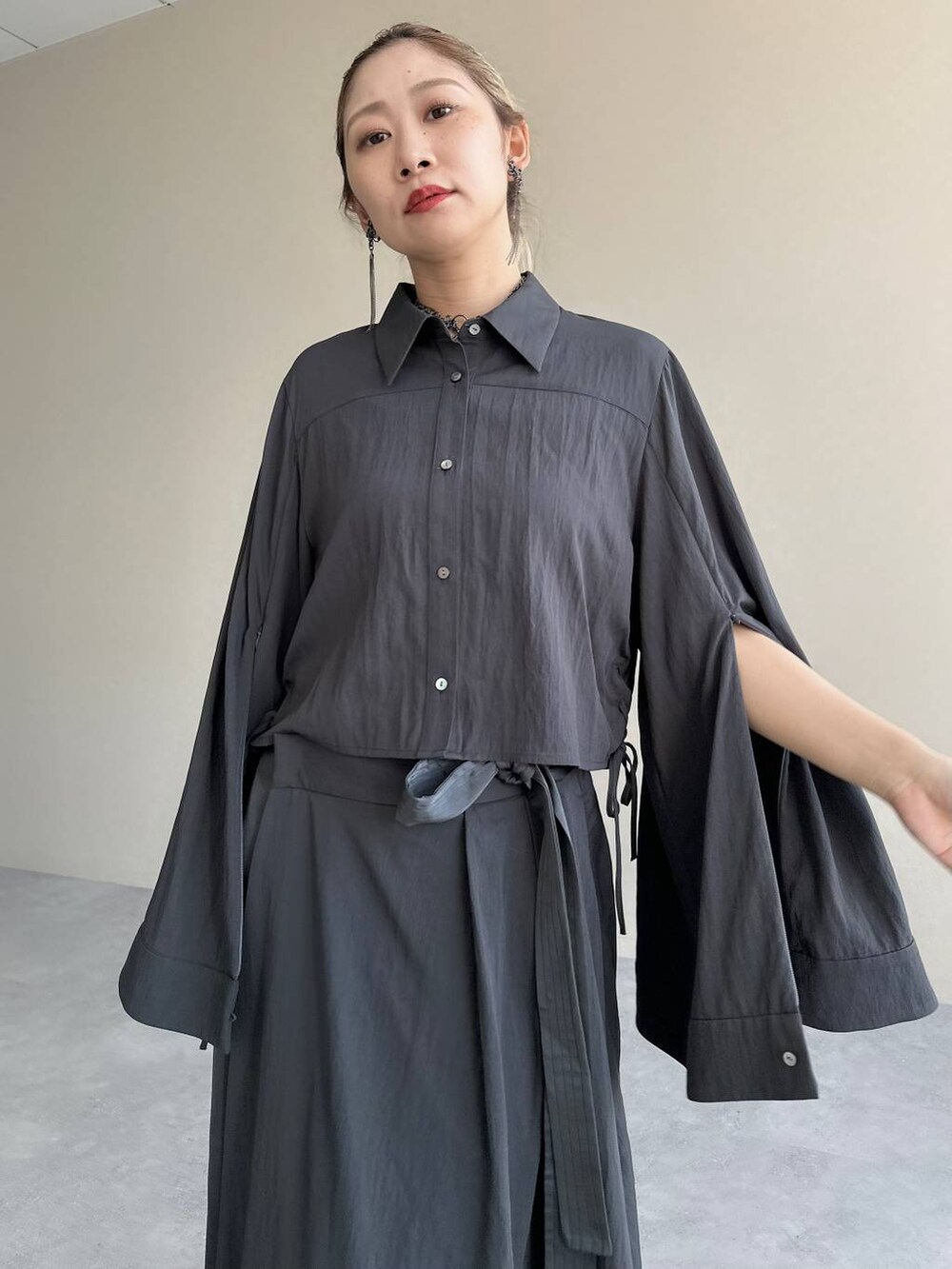 ブラック系のブーツ、グレー系のスカート、グレー系のシャツ/ブラウスを着用したレディースの秋コーディネートの2枚目の写真