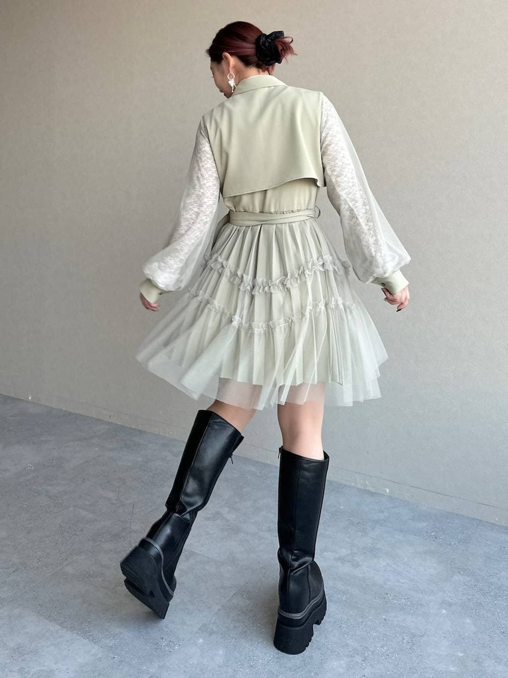 ブラック系のブーツ、ホワイト系のTシャツ/カットソー、イエロー系のワンピースを着用したレディースの冬コーディネートの2枚目の写真