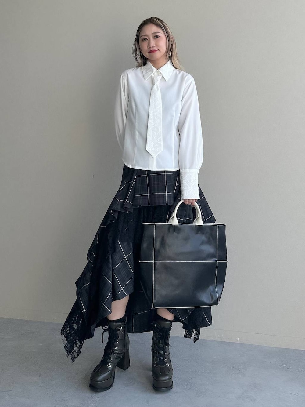 ブラック系のショルダーバッグ、ブラック系のスカート、ホワイト系のシャツ/ブラウスを着用したレディースの夏コーディネートの6枚目の写真