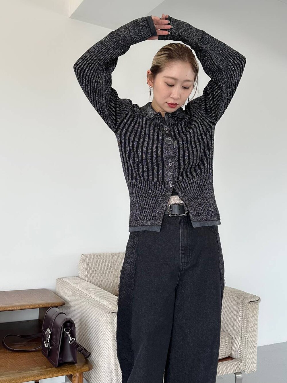 ブラック系のショルダーバッグ、ブラック系のデニムパンツ、ブラック系のブーツを着用したレディースの秋コーディネートの4枚目の写真