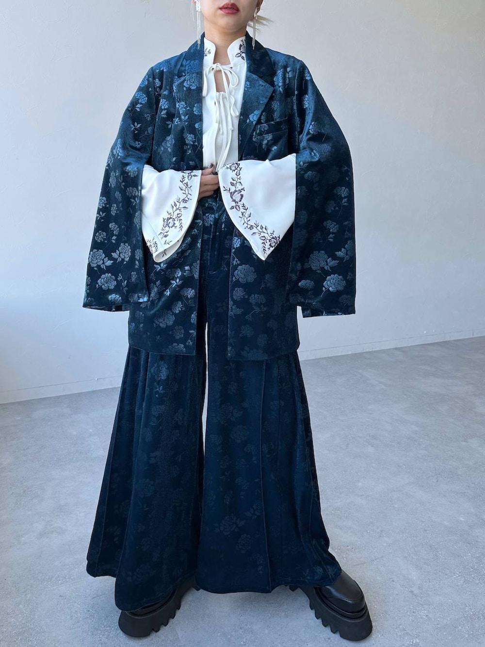 ホワイト系のシャツ/ブラウス、ブルー系のテーラードジャケット、ブラック系のブーツを着用したレディースの冬コーディネートの5枚目の写真