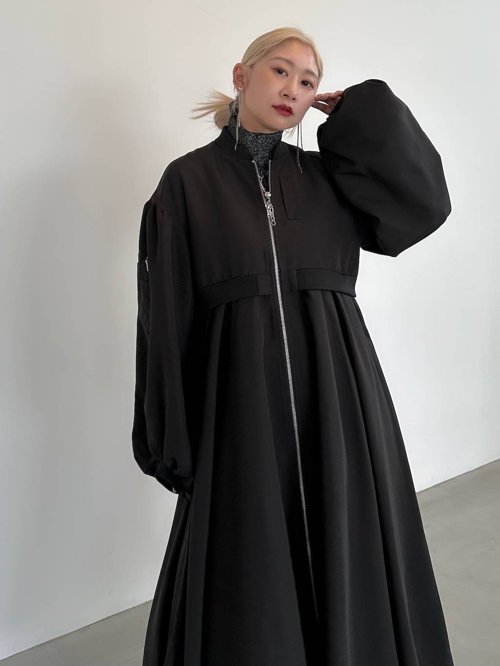 ブラック系のニット/セーター、ブラック系のブーツ、ブラック系のブルゾンを着用したレディースの秋コーディネートの5枚目の写真