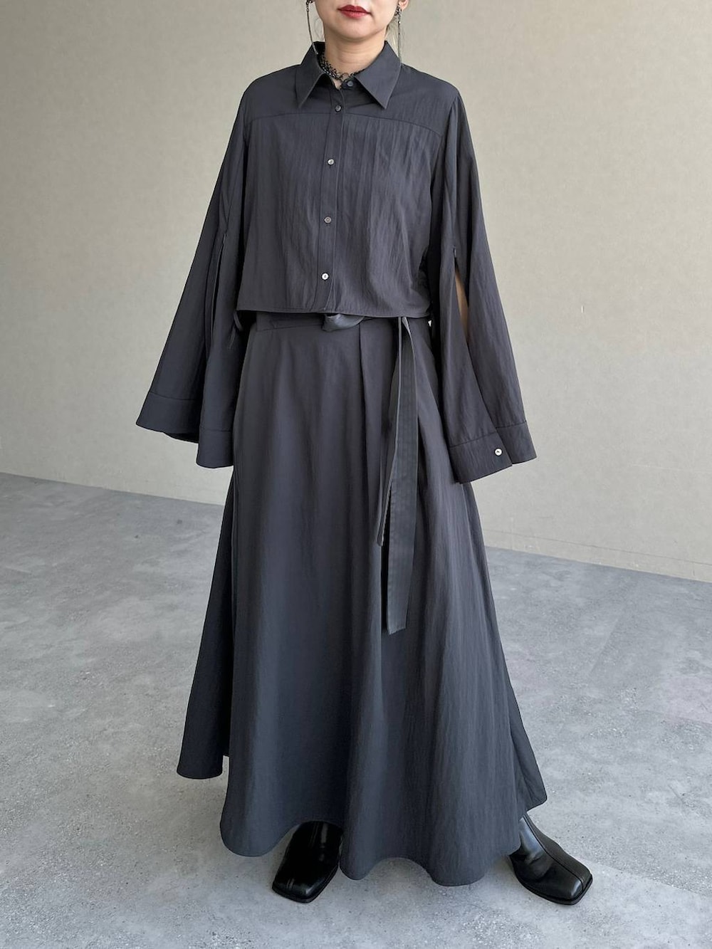 ブラック系のブーツ、グレー系のスカート、グレー系のシャツ/ブラウスを着用したレディースの秋コーディネートの6枚目の写真