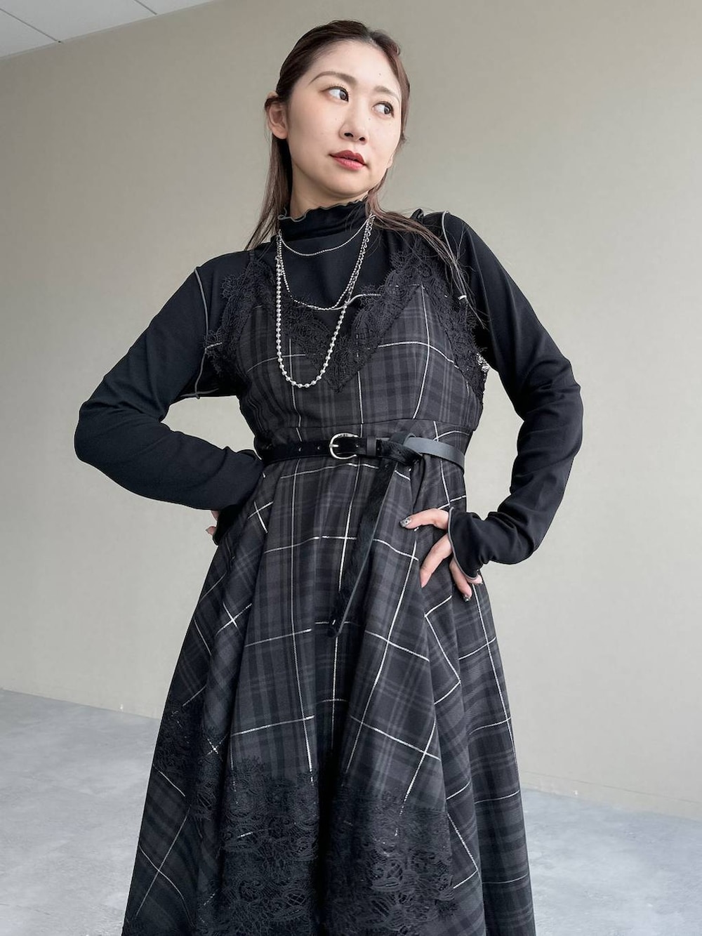 ブラック系のボストンバッグ、ブラック系のワンピース、ブラック系のブーツを着用したレディースの秋コーディネートの3枚目の写真