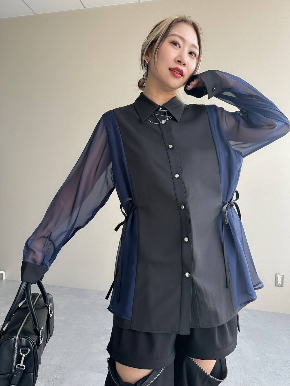 ブラック系のカーゴパンツ、ブラック系のボストンバッグ、シルバー系のブーツを着用したレディースの夏コーディネートの4枚目の写真