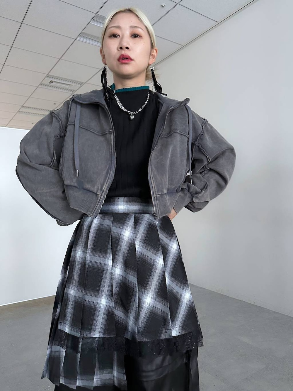 ブラック系のカーゴパンツ、ブラック系のニット/セーター、グレー系のパーカーを着用したレディースの冬コーディネートの8枚目の写真