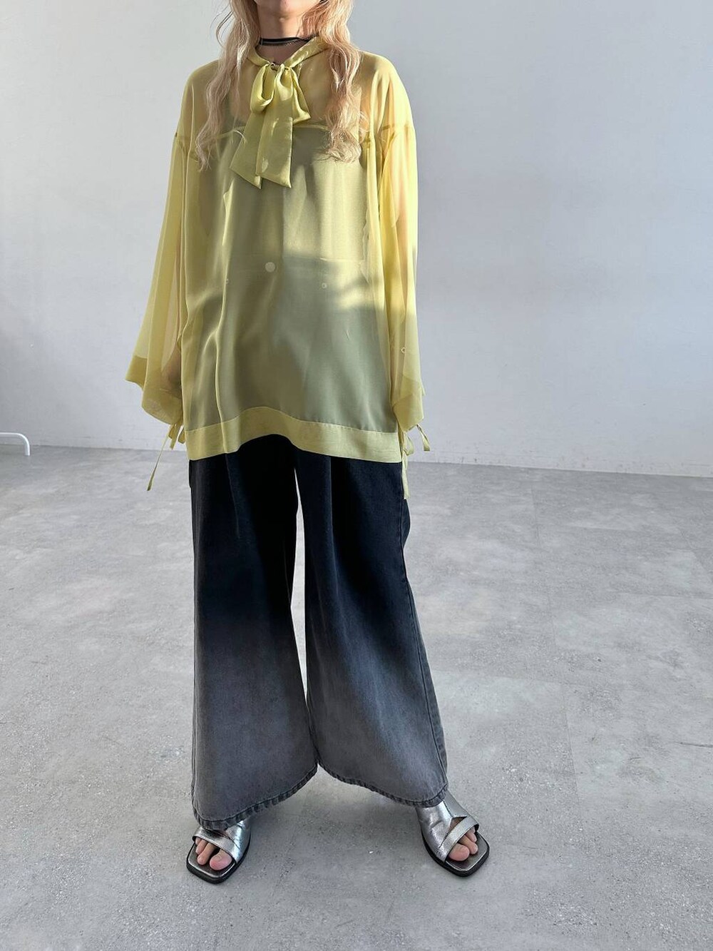 シルバー系のサンダル、ブラック系のデニムパンツ、イエロー系のTシャツ/カットソーを着用したレディースの春コーディネートの6枚目の写真