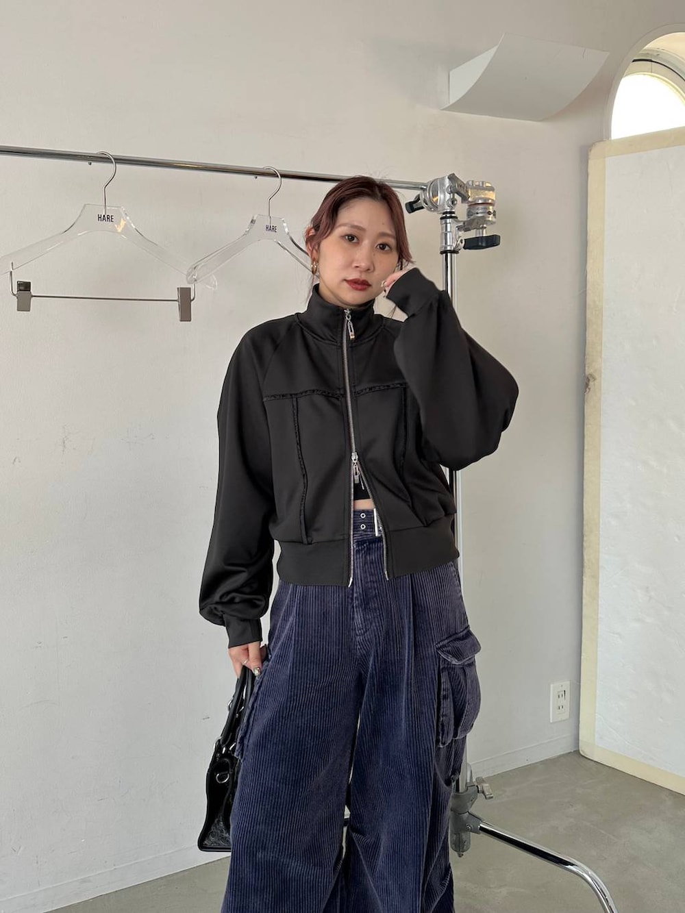 ブラック系のショルダーバッグ、ブルー系のパーカー、ブルー系のカーゴパンツを着用したレディースの秋コーディネートの8枚目の写真