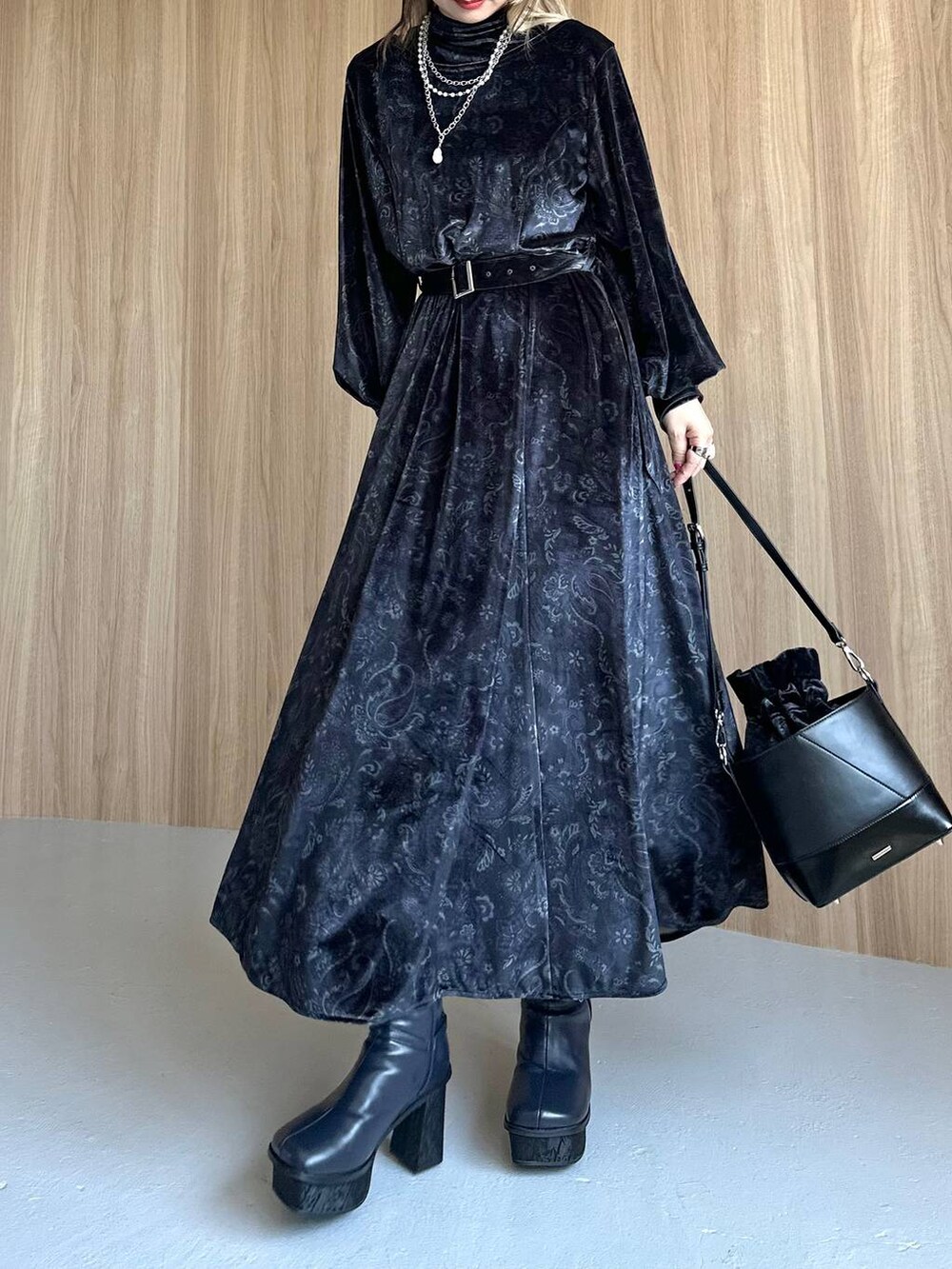 グレー系のワンピース、ブルー系のブーツ、ブラック系のショルダーバッグを着用したレディースの秋コーディネートの4枚目の写真