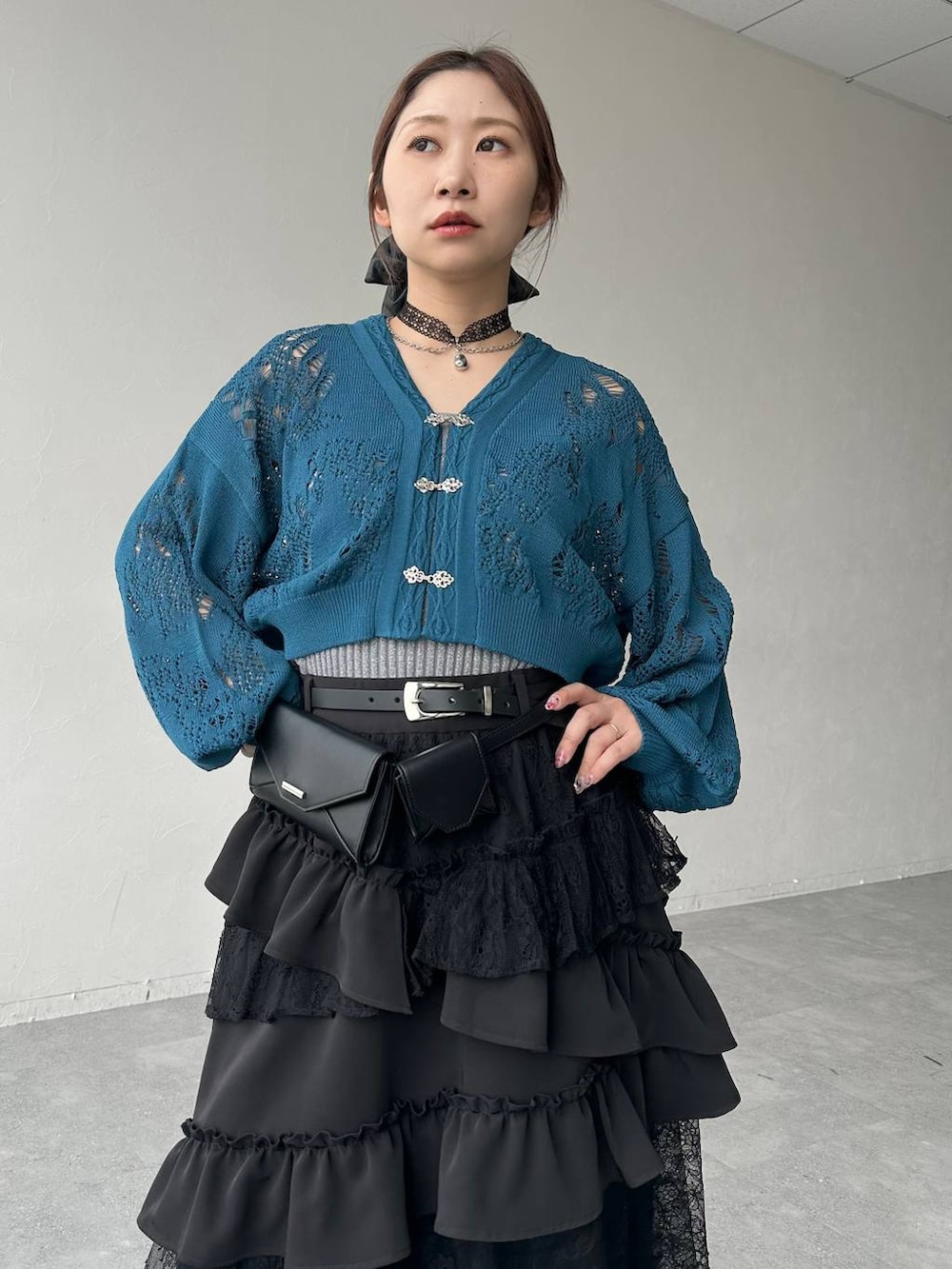 ブラック系のスカート、ブラック系のサンダル、ブルー系のデニムパンツを着用したレディースの春コーディネートの4枚目の写真