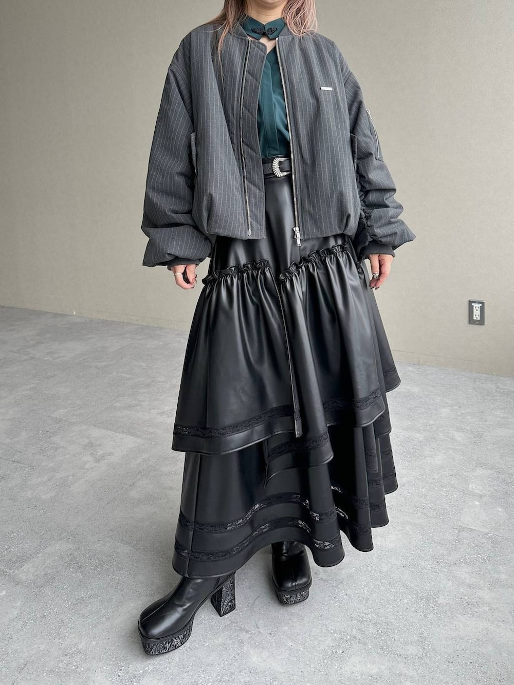 グレー系のブーツ、ブラック系のスカート、グリーン系のシャツ/ブラウスを着用したレディースの秋コーディネートの7枚目の写真