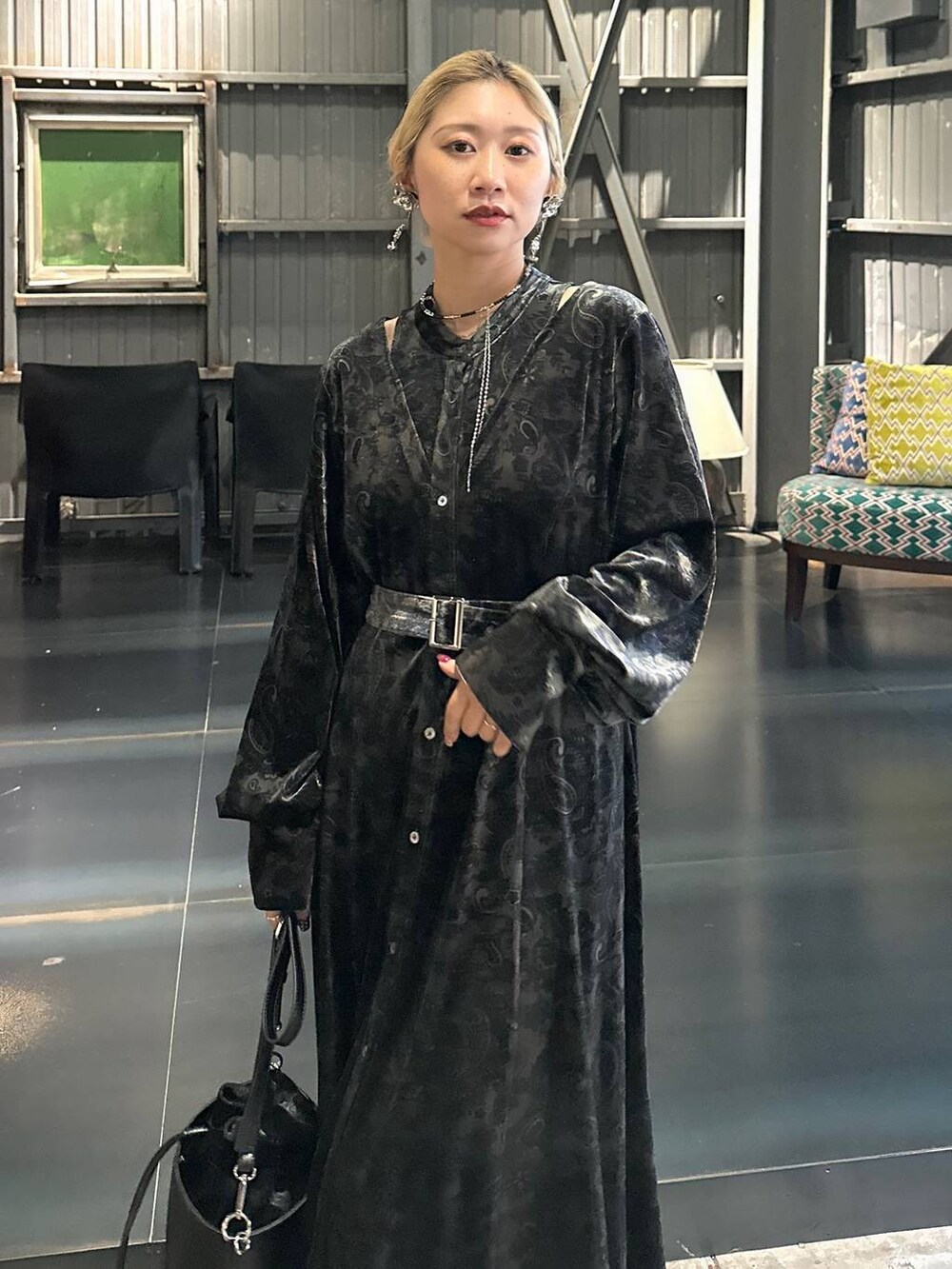 ブラック系のワンピース、レッド系のブーツ、ブラック系のショルダーバッグを着用したレディースの秋コーディネートの4枚目の写真