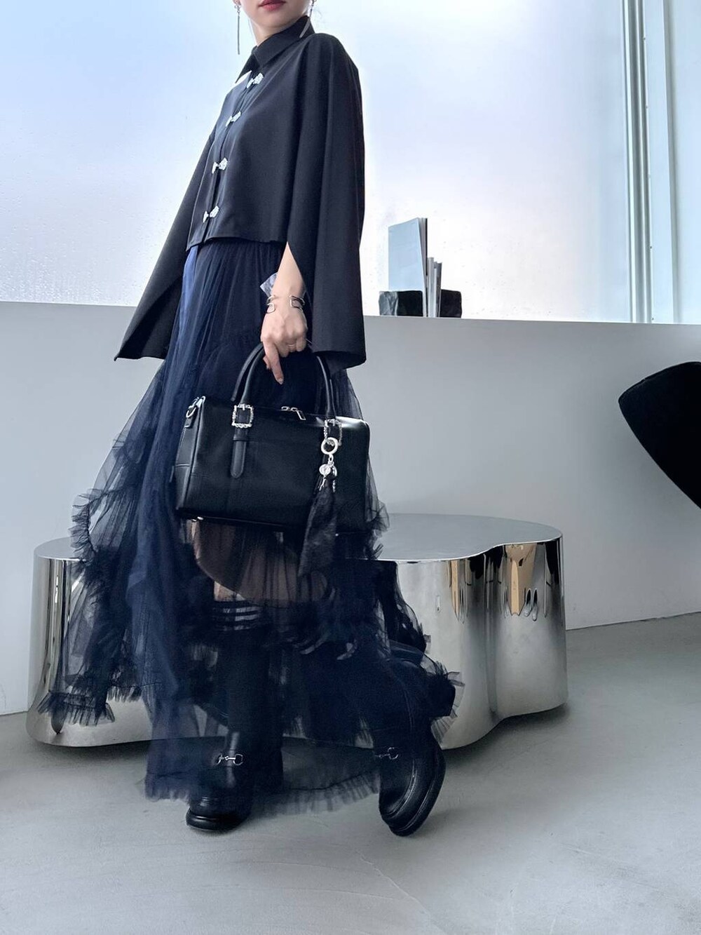 ブラック系のボストンバッグ、ブラック系のシャツ/ブラウス、ブラック系のローファーを着用したレディースの夏コーディネートの9枚目の写真