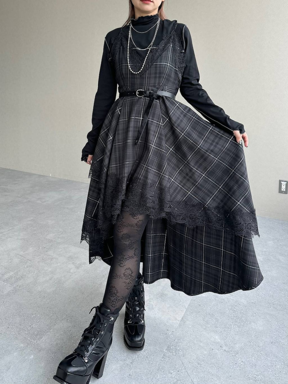 ブラック系のボストンバッグ、ブラック系のワンピース、ブラック系のブーツを着用したレディースの秋コーディネートの5枚目の写真