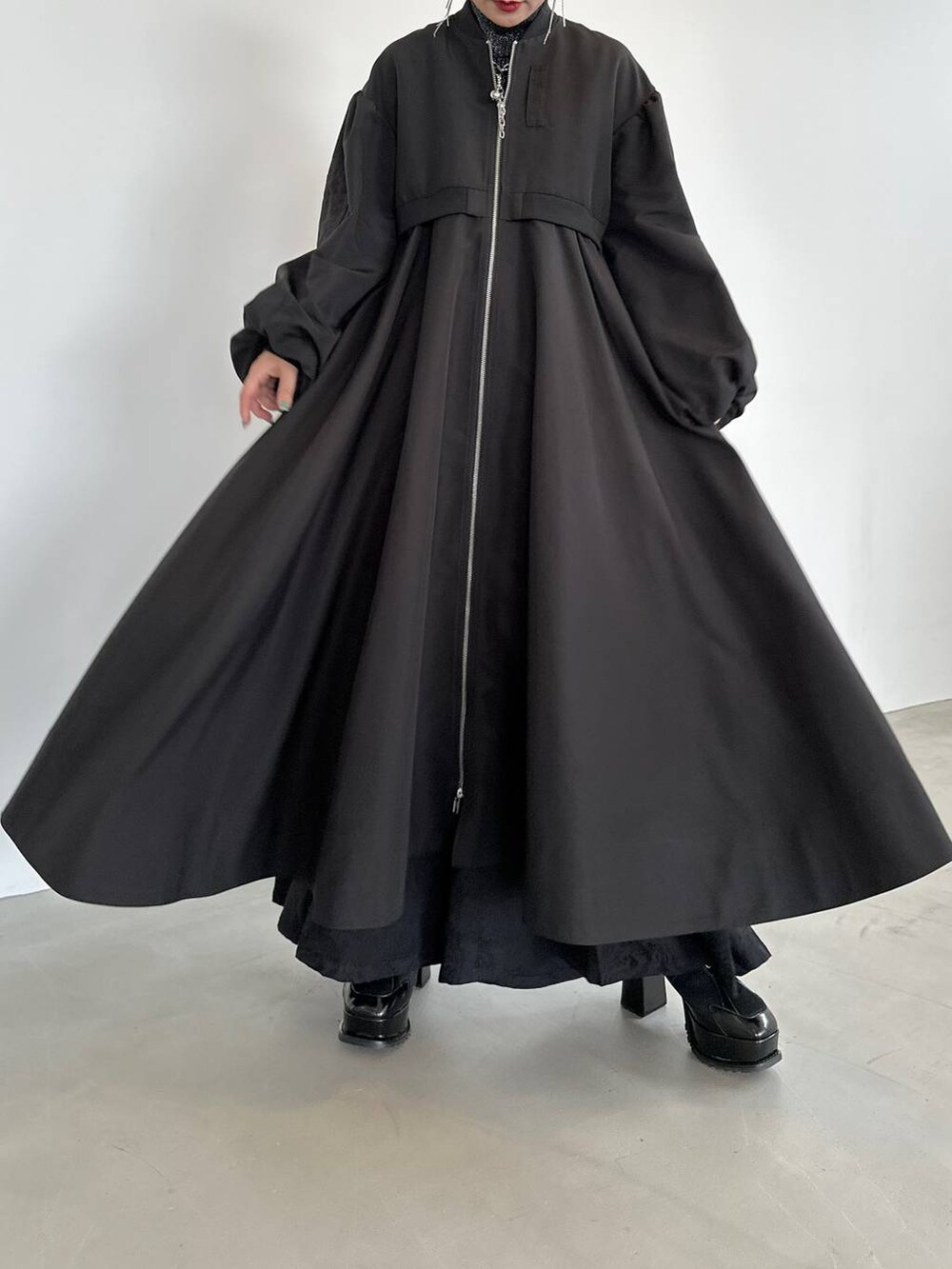 ブラック系のニット/セーター、ブラック系のブーツ、ブラック系のブルゾンを着用したレディースの秋コーディネートの9枚目の写真