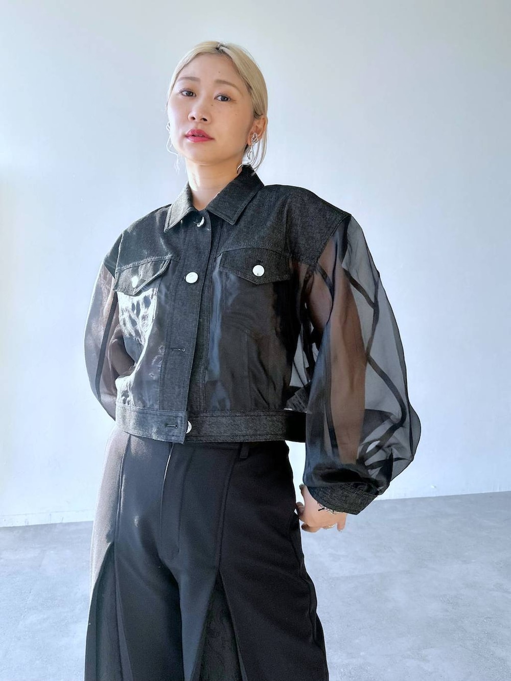 ブラック系のスラックス、ブラック系のパンプス、ブラック系のブルゾンを着用したレディースの夏コーディネートの7枚目の写真