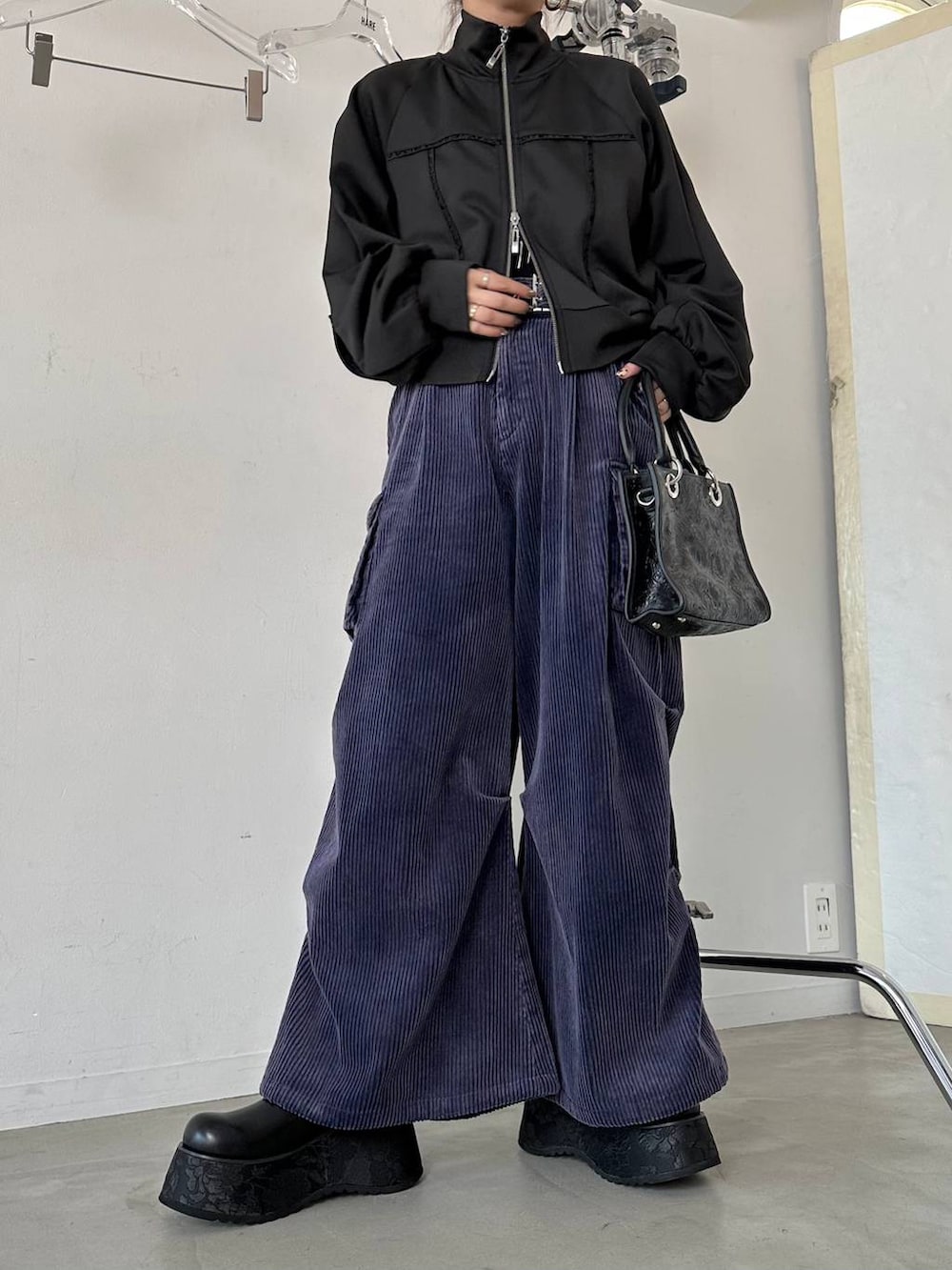 ブラック系のショルダーバッグ、ブルー系のパーカー、ブルー系のカーゴパンツを着用したレディースの秋コーディネートの7枚目の写真