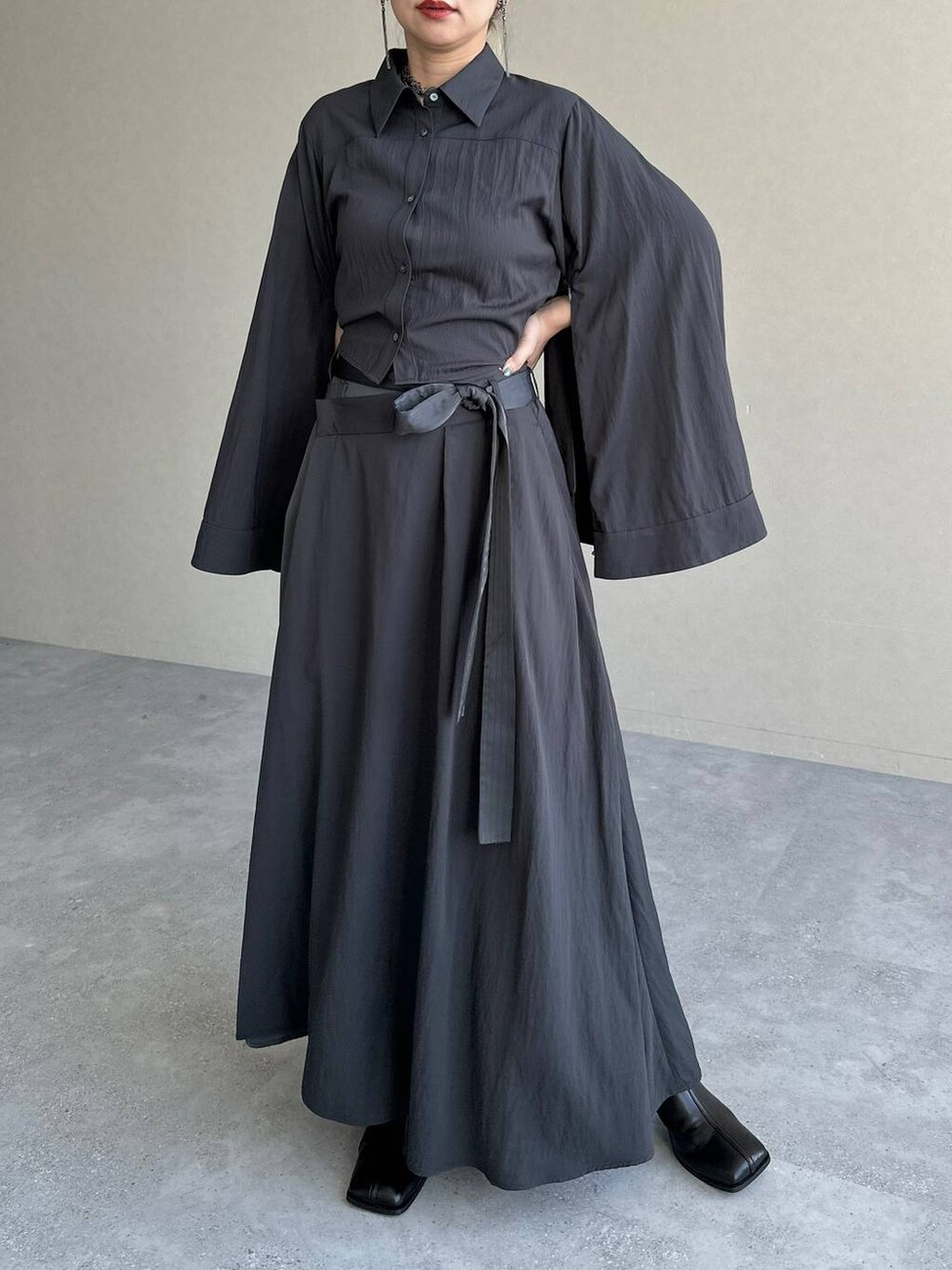 ブラック系のブーツ、グレー系のスカート、グレー系のシャツ/ブラウスを着用したレディースの秋コーディネートの5枚目の写真